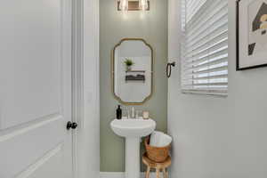 View of  main floor half bathroom with accent wall.
