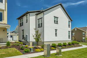 View of home's exterior with stucco siding, a yard, and central AC