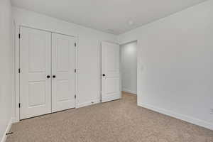 Third Bedroom Unfurnished with light carpet, baseboards, and a closet