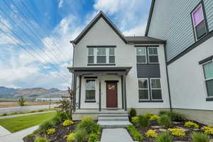 View of front of home with stucco siding, a mountain view, and a porch