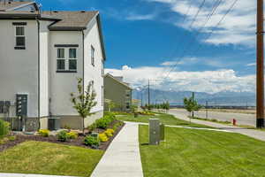 View of green lawn with a mountain view and central air condition unit
