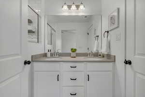 Primary suite full bathroom with double vanity and a tile shower