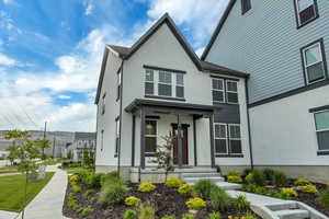 View of front of house with stucco siding and covered porch