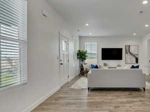 Living area featuring light wood-type flooring and recessed lighting with beautiful mountain and field views.