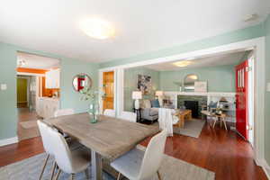 Dining area featuring wood finished floors, a tile fireplace, and baseboards