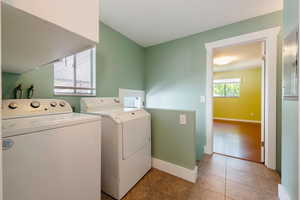 Laundry room with washer and dryer, baseboards, and light tile patterned floors