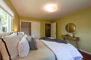 Bedroom with a closet, wood finished floors, and baseboards