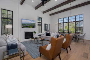 Living room featuring a chandelier, beamed ceiling, light wood-style floors, recessed lighting, and plenty of natural light