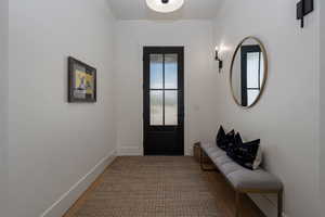 Doorway with baseboards and wood finished floors