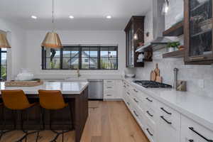 Kitchen with appliances with stainless steel finishes, a sink, plenty of natural light, light countertops, and recessed lighting