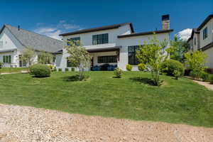 View of front of house featuring a chimney and a front yard