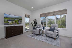 Living area with light carpet, healthy amount of natural light, recessed lighting, and baseboards