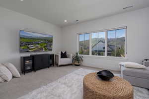 Living area featuring light colored carpet, recessed lighting, and baseboards