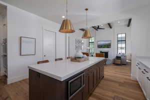 Kitchen featuring stainless steel microwave, light wood-style floors, light countertops, recessed lighting, and dark brown cabinets
