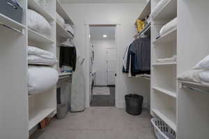 Walk in closet with estacked washer and dryer and carpet floors