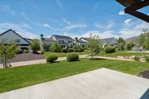 View of green lawn featuring a patio area and a residential view