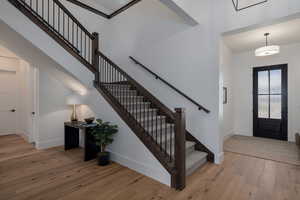 Foyer featuring wood finished floors, baseboards, stairs, and a high ceiling