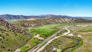 Aerial view of property and surrounding area featuring a mountain backdrop and property boundaries highlighted