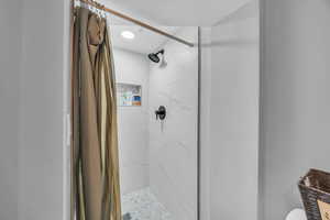 Bathroom featuring a stall shower and toilet