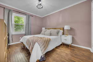 Bedroom featuring hardwood / wood-style floors, baseboards, a textured ceiling, and ornamental molding