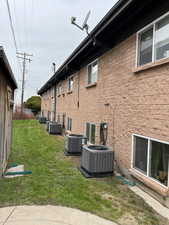 View of home's exterior with central AC and a yard