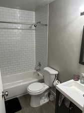 Full bath featuring toilet, wood finished floors, shower / bath combination, and vanity