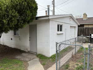 View of side of property with concrete block siding and a gate