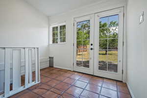 Doorway to outside with french doors, baseboards, and tile patterned floors