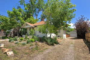 View of front of house featuring a chimney, an outbuilding, and a detached garage