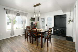 Dining room with dark wood-type flooring, baseboards, and french doors