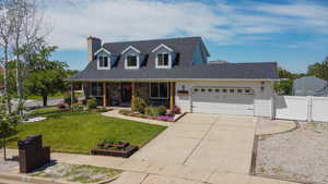 Cape cod house with a garage, a porch, a gate, a chimney, and driveway