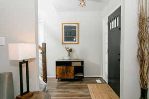 Entryway featuring dark wood finished floors and baseboards