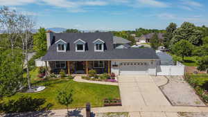 Cape cod-style house featuring a gate, an attached garage, a porch, concrete driveway, and a shingled roof