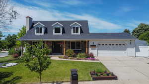Cape cod home featuring a garage, driveway, roof with shingles, and a chimney