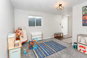 Recreation room featuring carpet flooring and baseboards