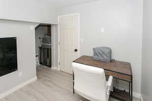 Home office featuring light wood-style floors and baseboards