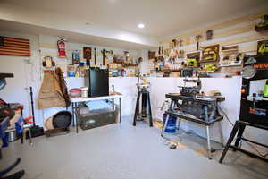 Miscellaneous room with recessed lighting, a workshop area, and speckled floor