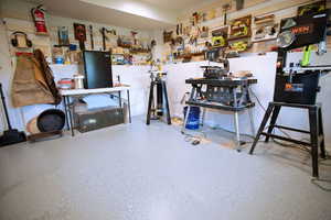 Miscellaneous room with speckle patterned floor and a workshop area