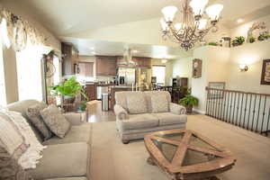 Living area featuring a chandelier, recessed lighting, and high vaulted ceiling