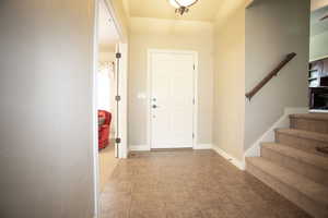 Foyer entrance featuring stairs and tile patterned floors