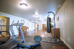 Workout area with wood finished floors and baseboards