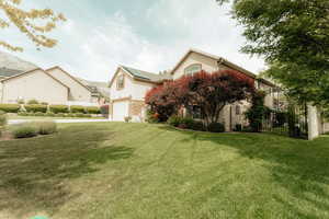 View of side of property with an attached garage, roof mounted solar panels, stucco siding, and concrete driveway