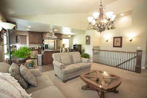 Living room featuring a chandelier, high vaulted ceiling, and recessed lighting