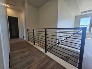 Hallway with an upstairs landing, wood finished floors, and baseboards