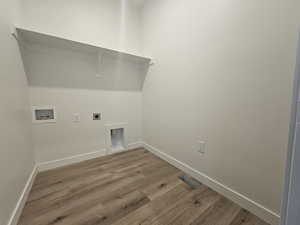 Laundry area with washer hookup, wood finished floors, baseboards, and electric dryer hookup