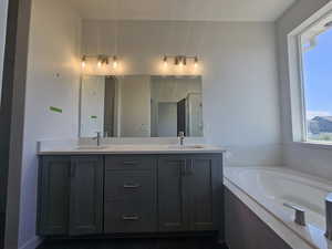 Full bathroom with double vanity, a garden tub, and a stall shower