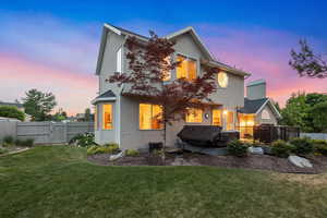 Rear view of property featuring stucco siding, a gate, and a wooden deck
