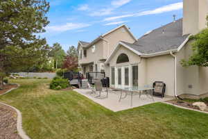 Rear view of property with a patio area, stucco siding, a wooden deck, and a shingled roof