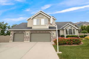 View of front of house with driveway, a mountain view, stucco siding, and an attached garage