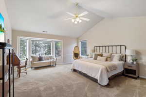 Carpeted bedroom featuring lofted ceiling, baseboards, and a ceiling fan